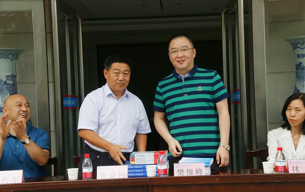 新乡市牧野区税务局党委书记、局长樊保峰向乐动(中国)党委书记张会民赠送税法知识书籍.jpg